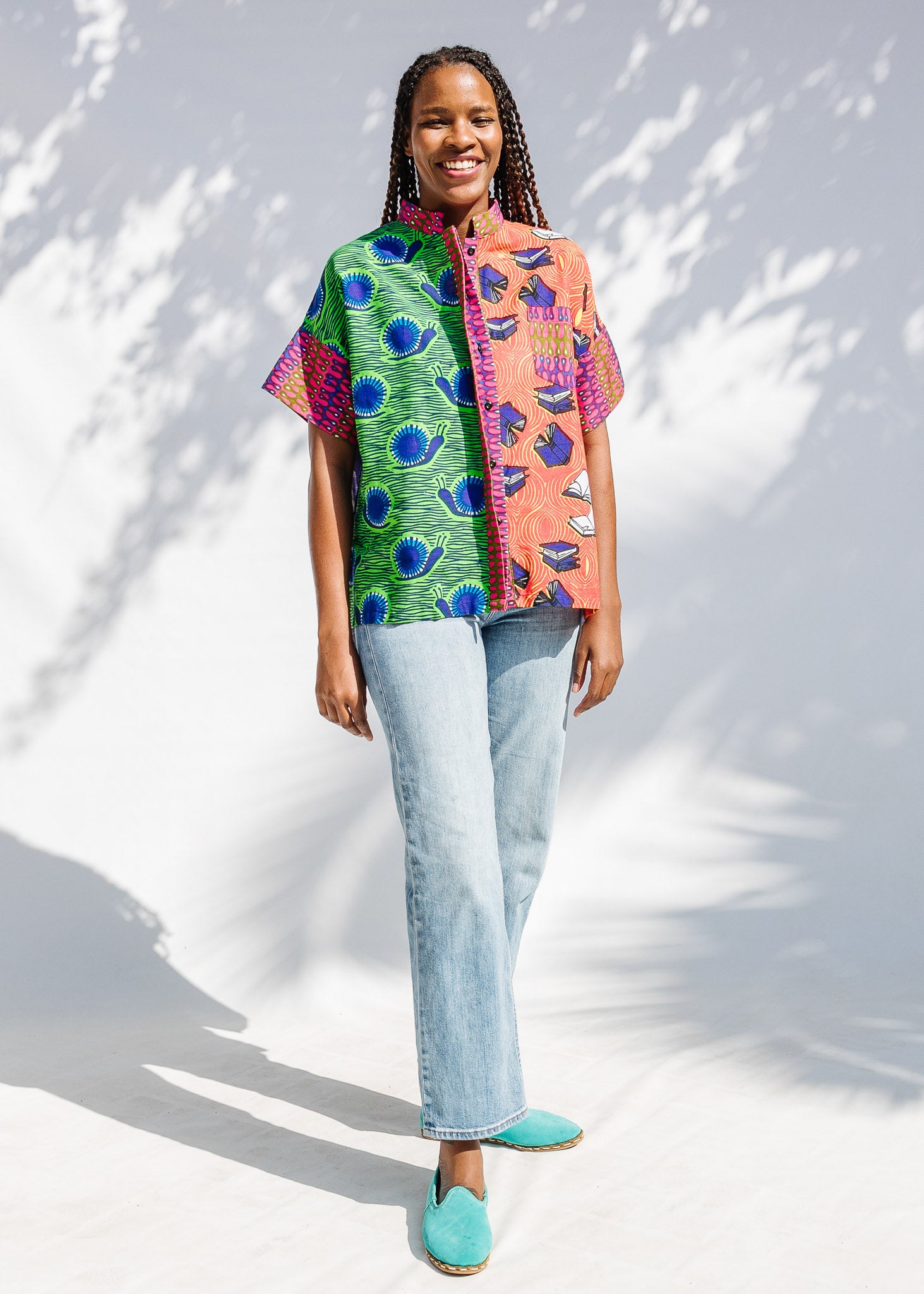 Model wearing green, orange and pink multiprint shirt.