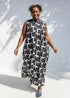 Model wearing black and white floral print, sleeveless dress.