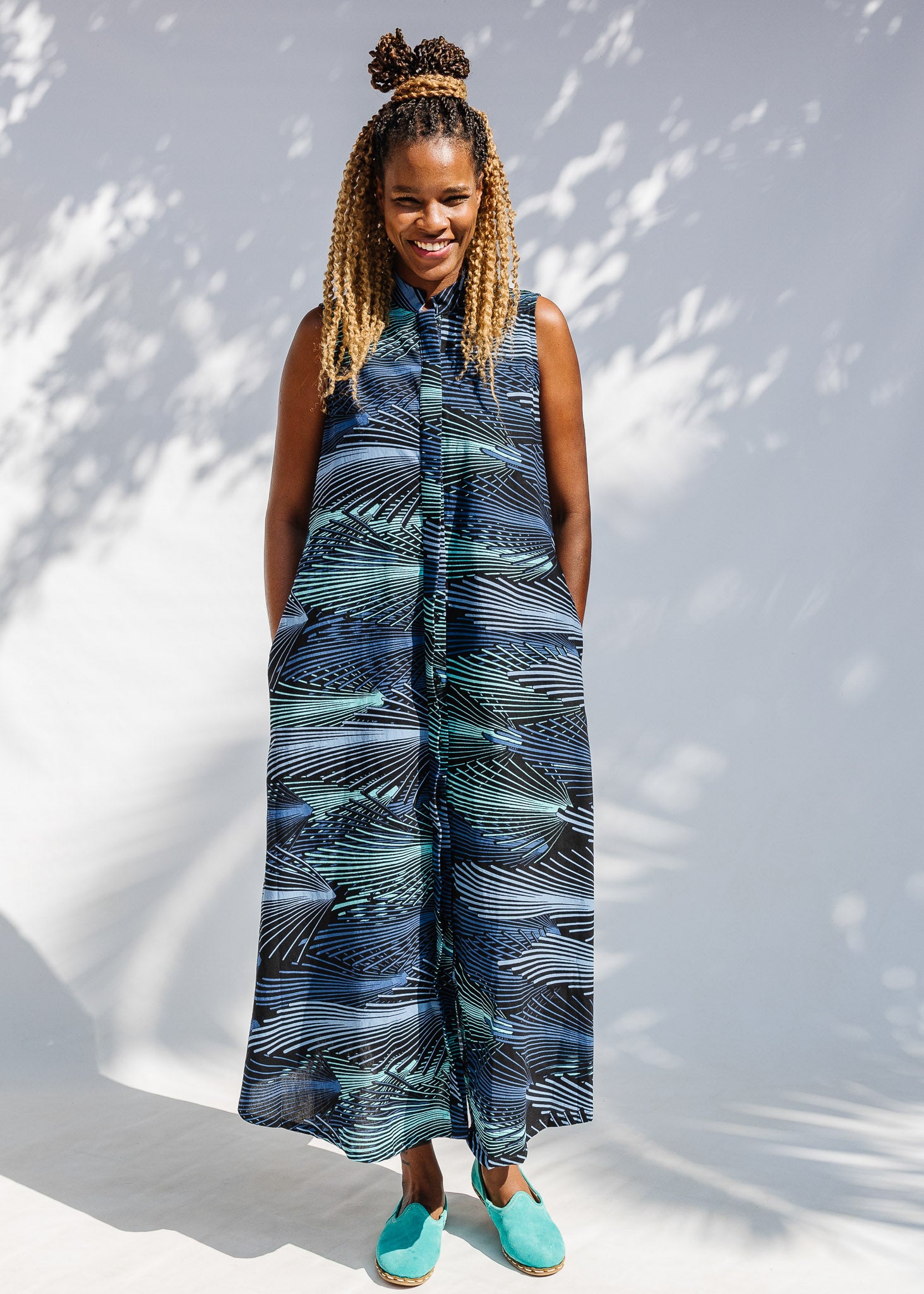 Model wearing black dress with aqua and navy abstract print.