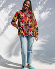 Model wearing multicolored puzzle print shirt.