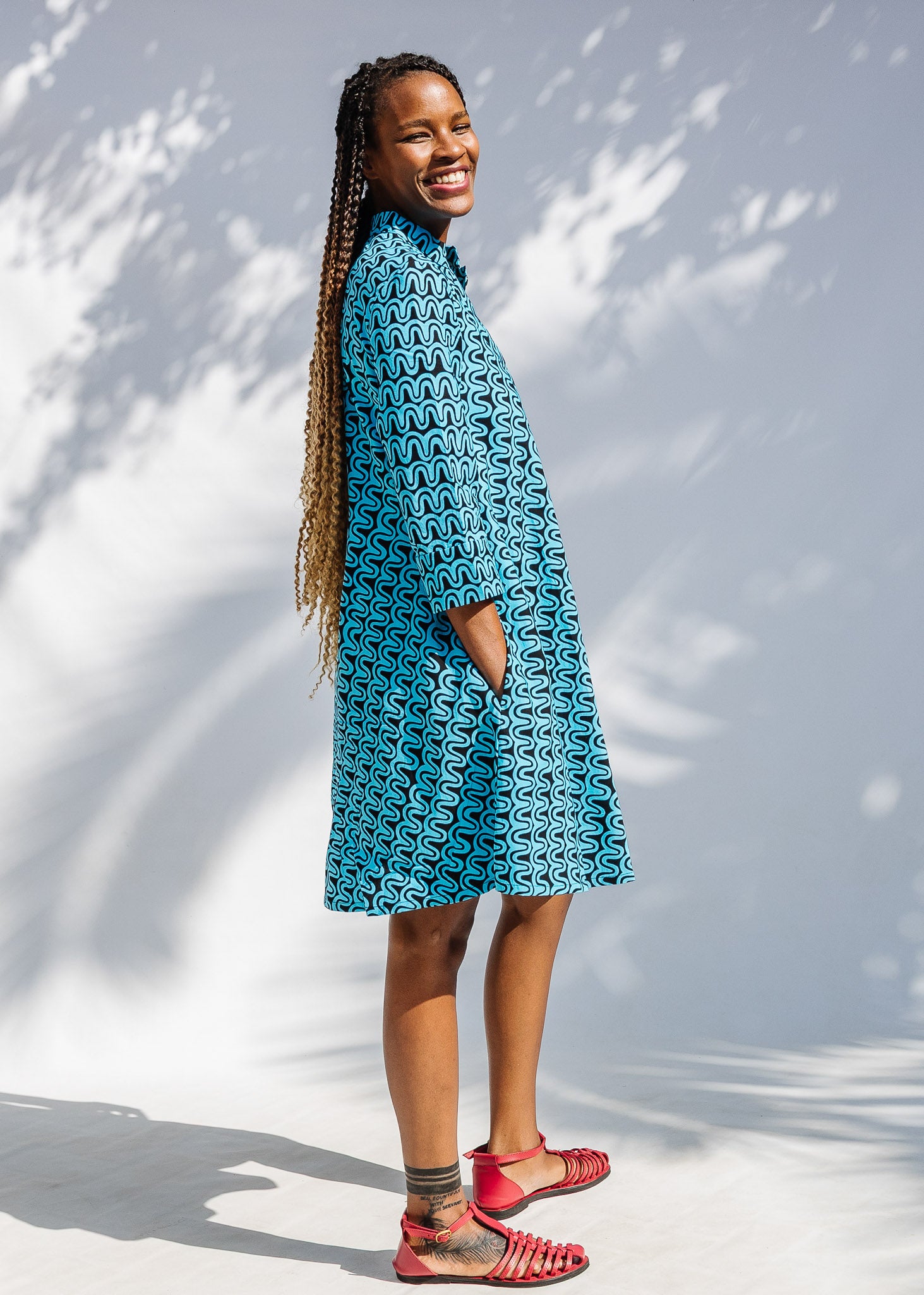 Model wearing blue and black squiggle print dress.