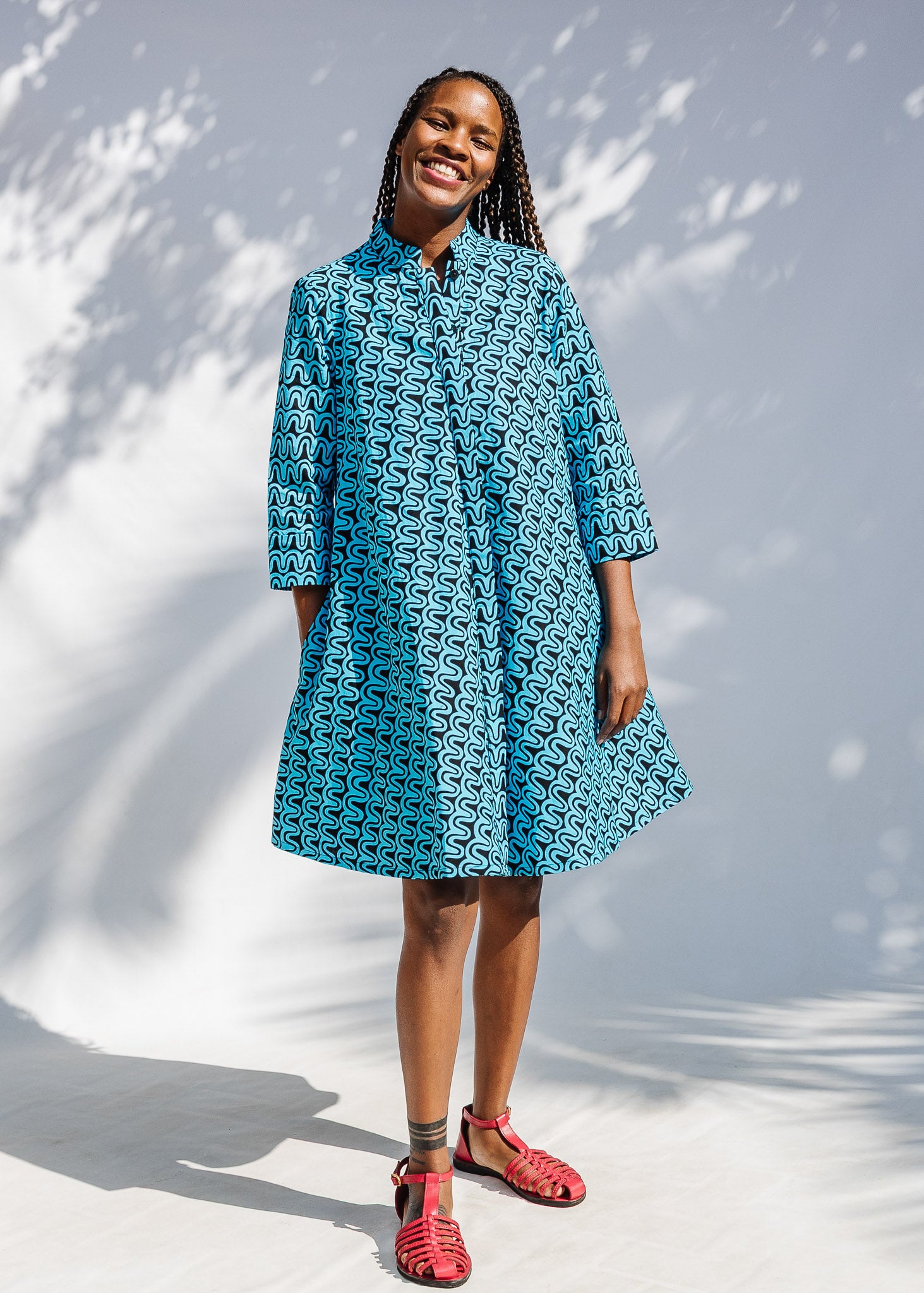 Model wearing blue and black squiggle print dress.