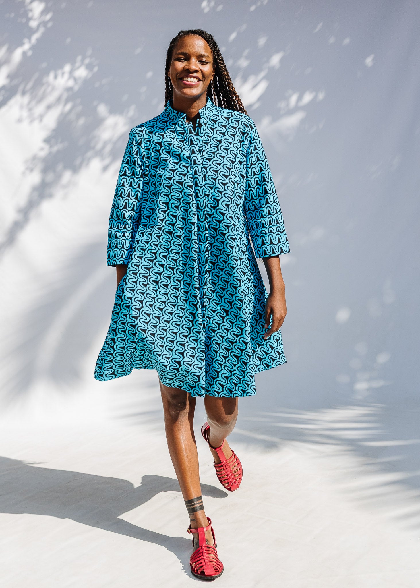 Model wearing blue and black squiggle print dress.