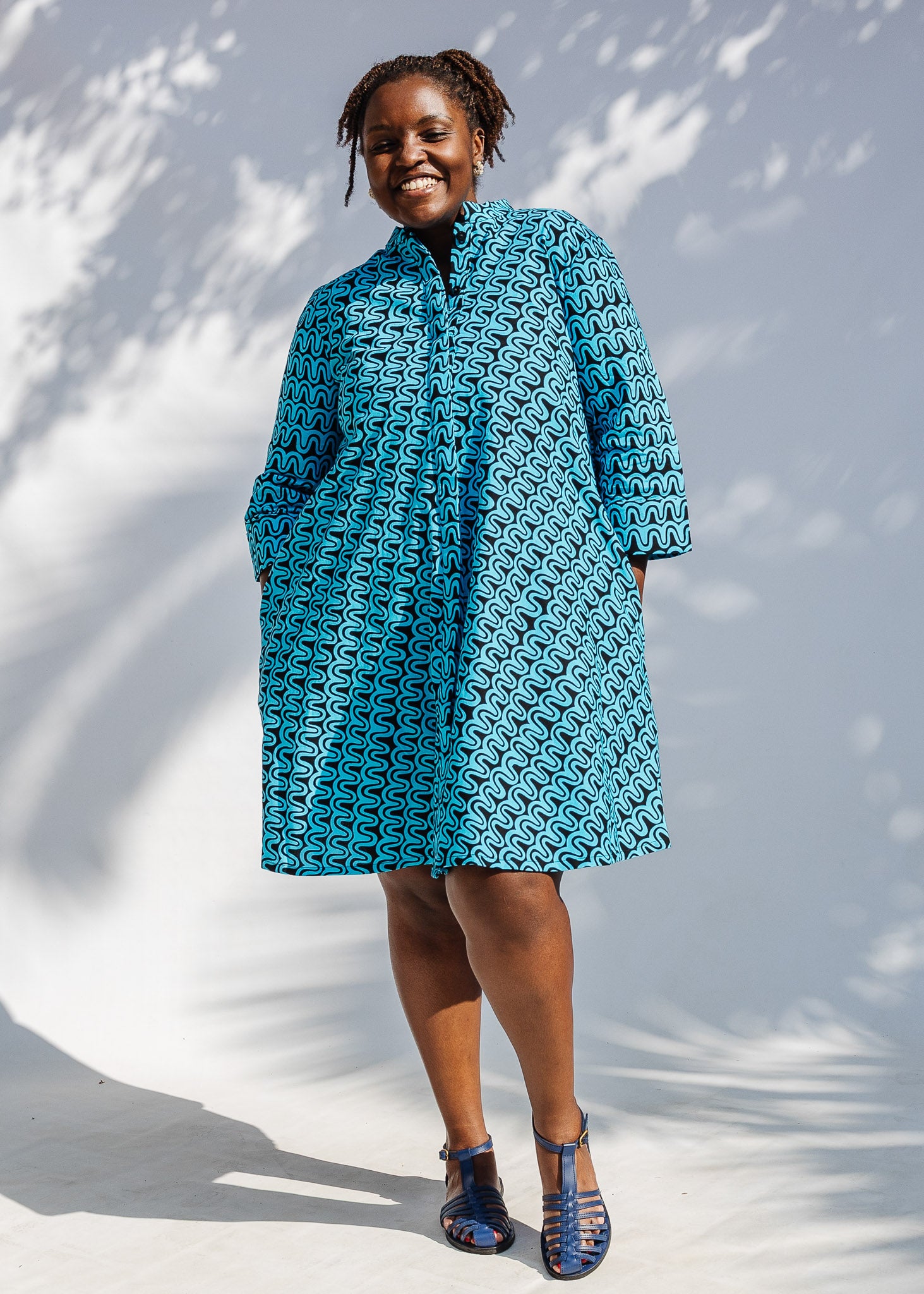 Model wearing blue and black squiggle print dress.