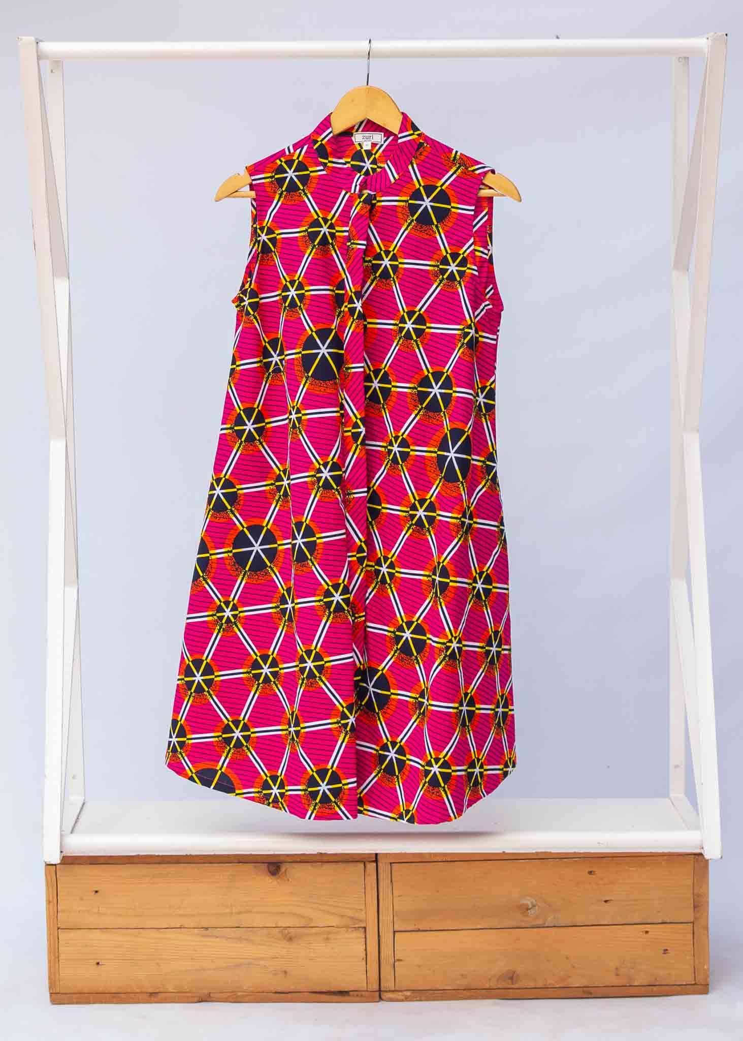Display of fuchsia dress with black dots and white and yellow lines.