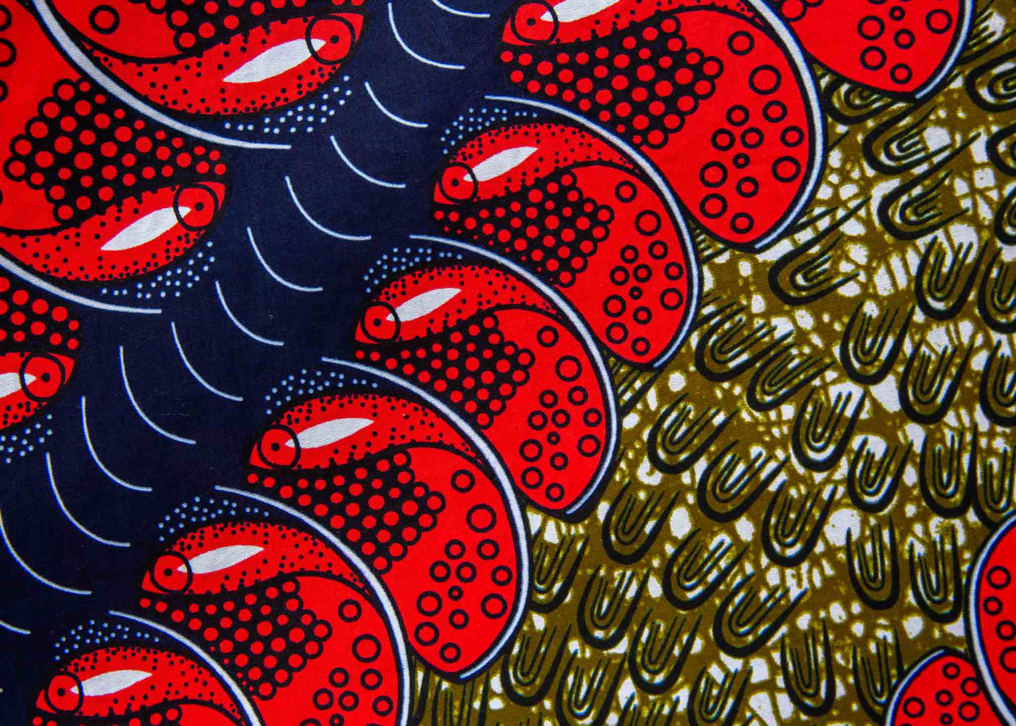 Display of green dress, with bold red and navy fish print.
