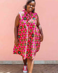 Model wearing sleeveless fuchsia dress with black dots and white and yellow lines.
