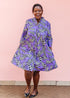 The model is wearing purple, black and white geometric print dress