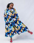 Model wearing blue, black, orange, yellow and white geometric print shirt and pant set.