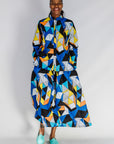 Model wearing blue, black, orange, yellow, orange and white geometric print shirt and culotte.