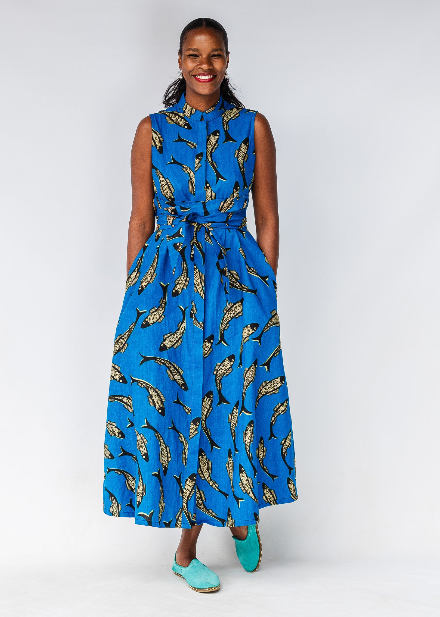 Model wearing blue dress with beige fish print.
