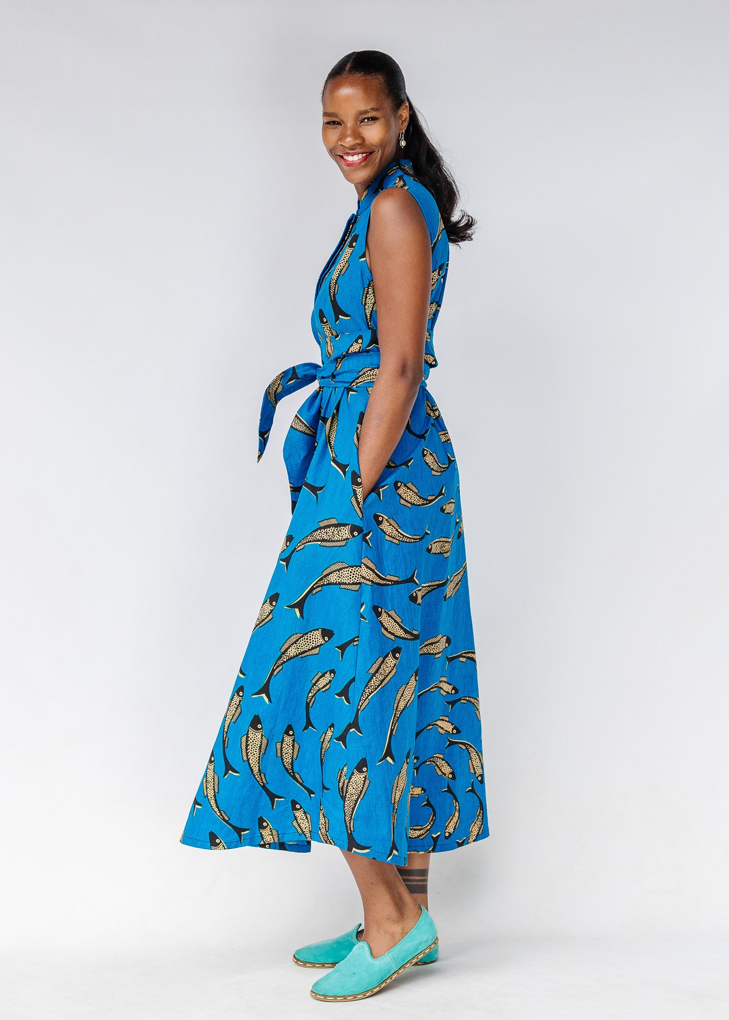 Model wearing blue dress with beige fish print.
