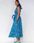Model wearing blue dress with beige fish print.