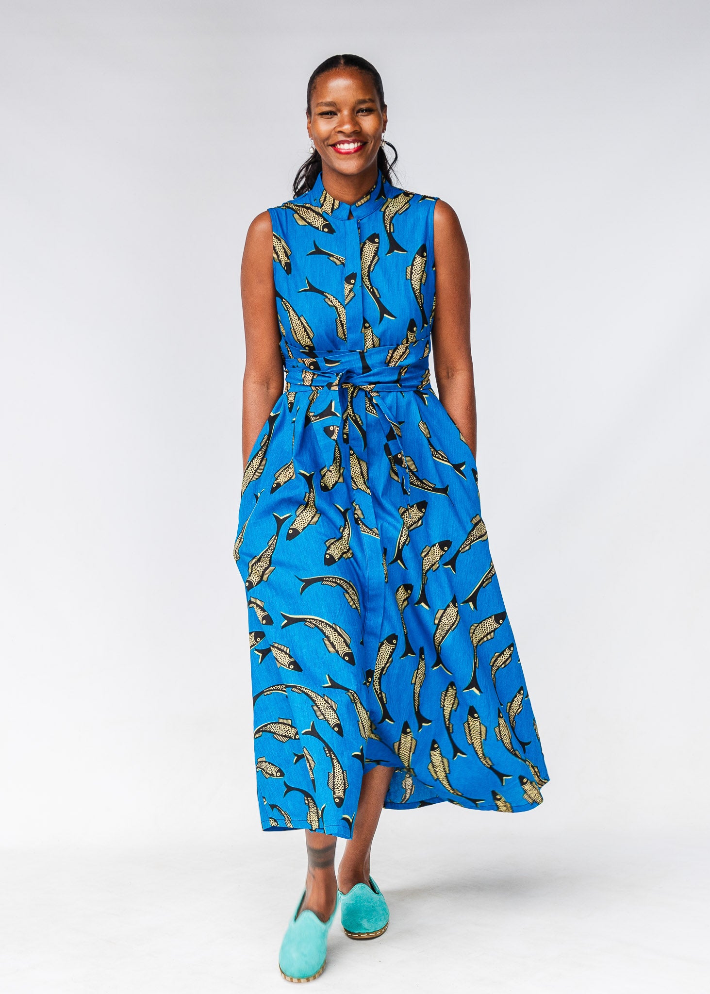 Model wearing blue dress with beige fish print.