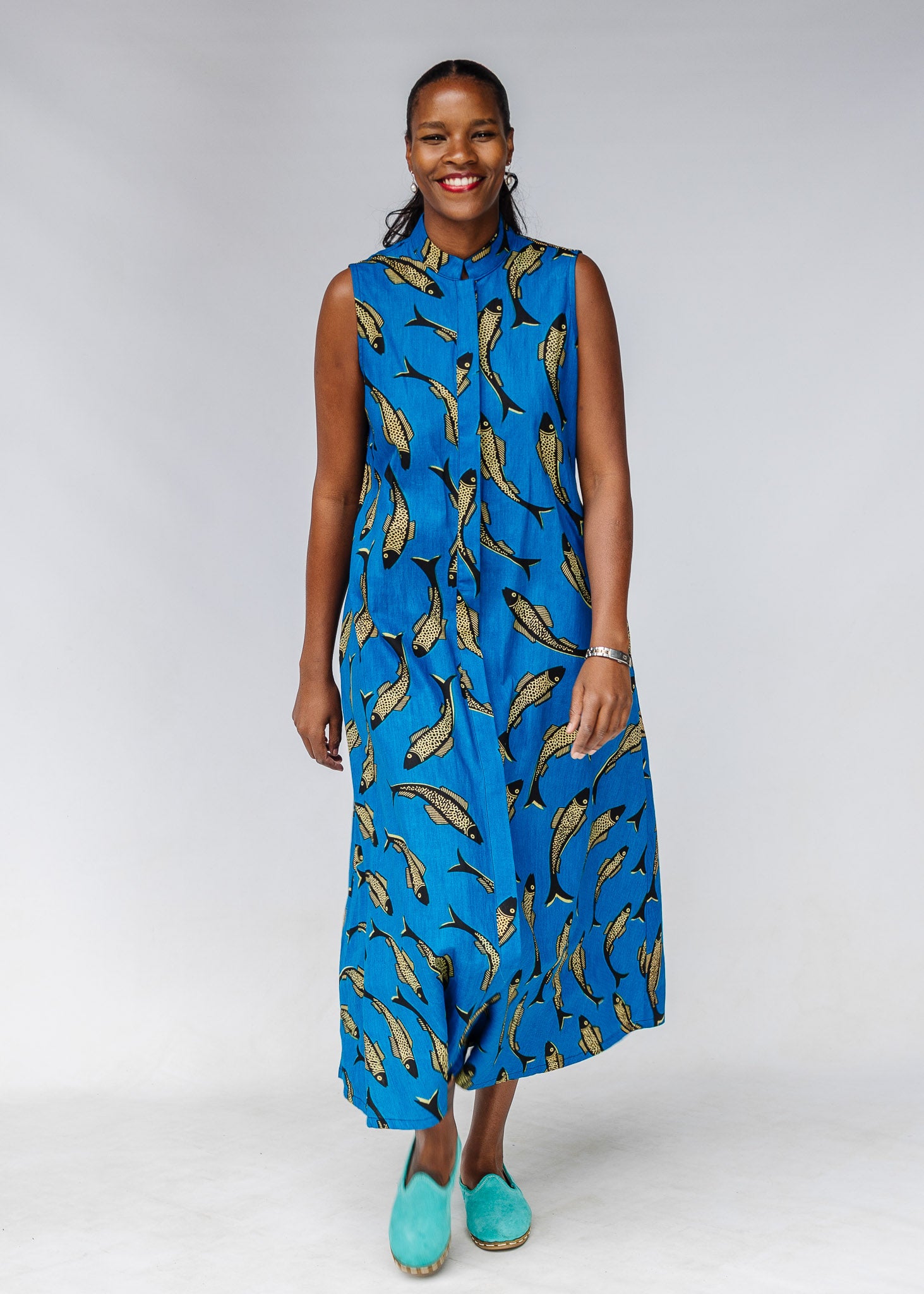Model wearing blue dress with beige fish print.