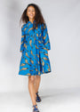 Model wearing blue dress with beige fish print.
