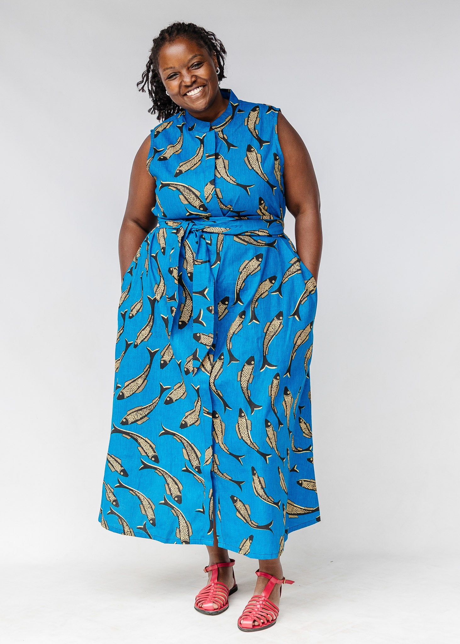 Model wearing blue dress with beige fish print.