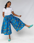 Model wearing white shirt with blue pants with beige fish print.