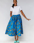 Model wearing white shirt with blue pants with beige fish print.