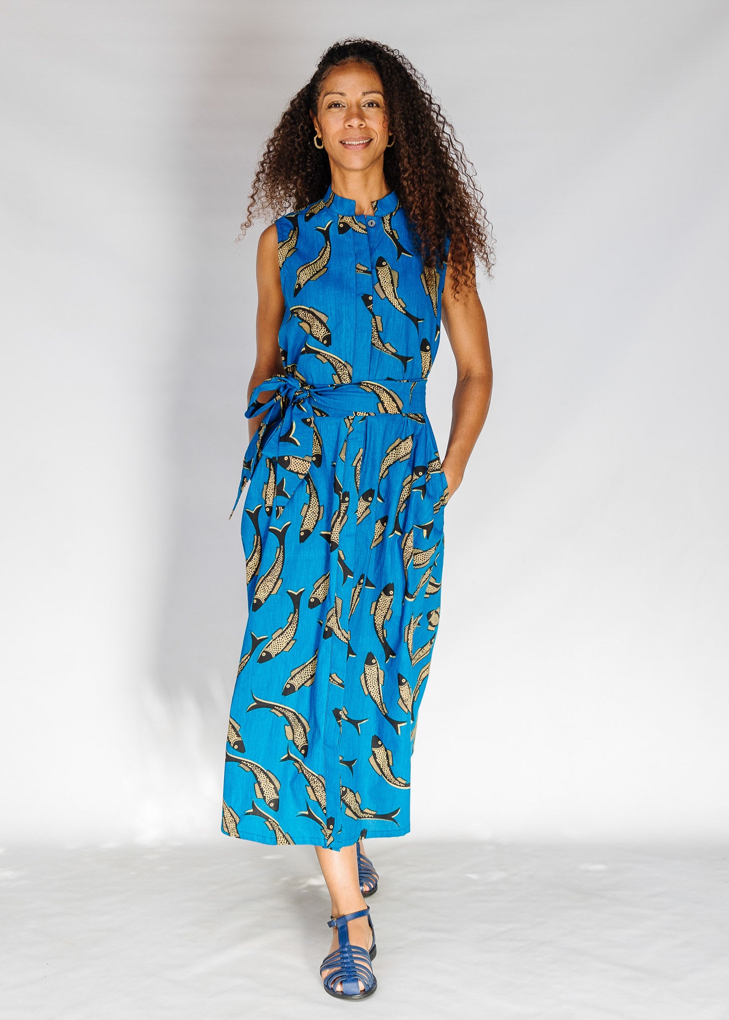 Model wearing blue dress with beige fish print.
