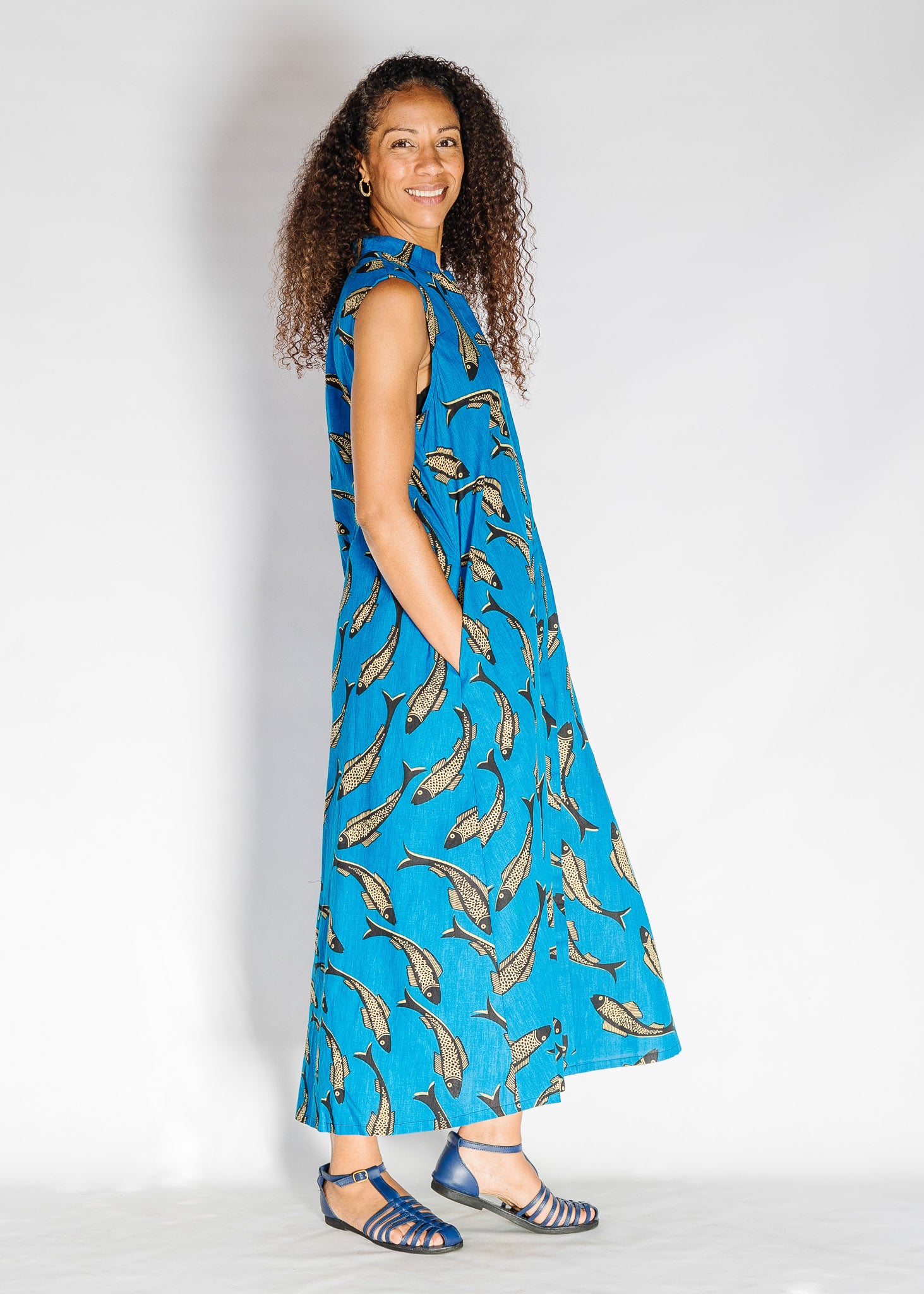 Model wearing blue dress with beige fish print.
