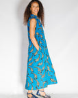 Model wearing blue dress with beige fish print.