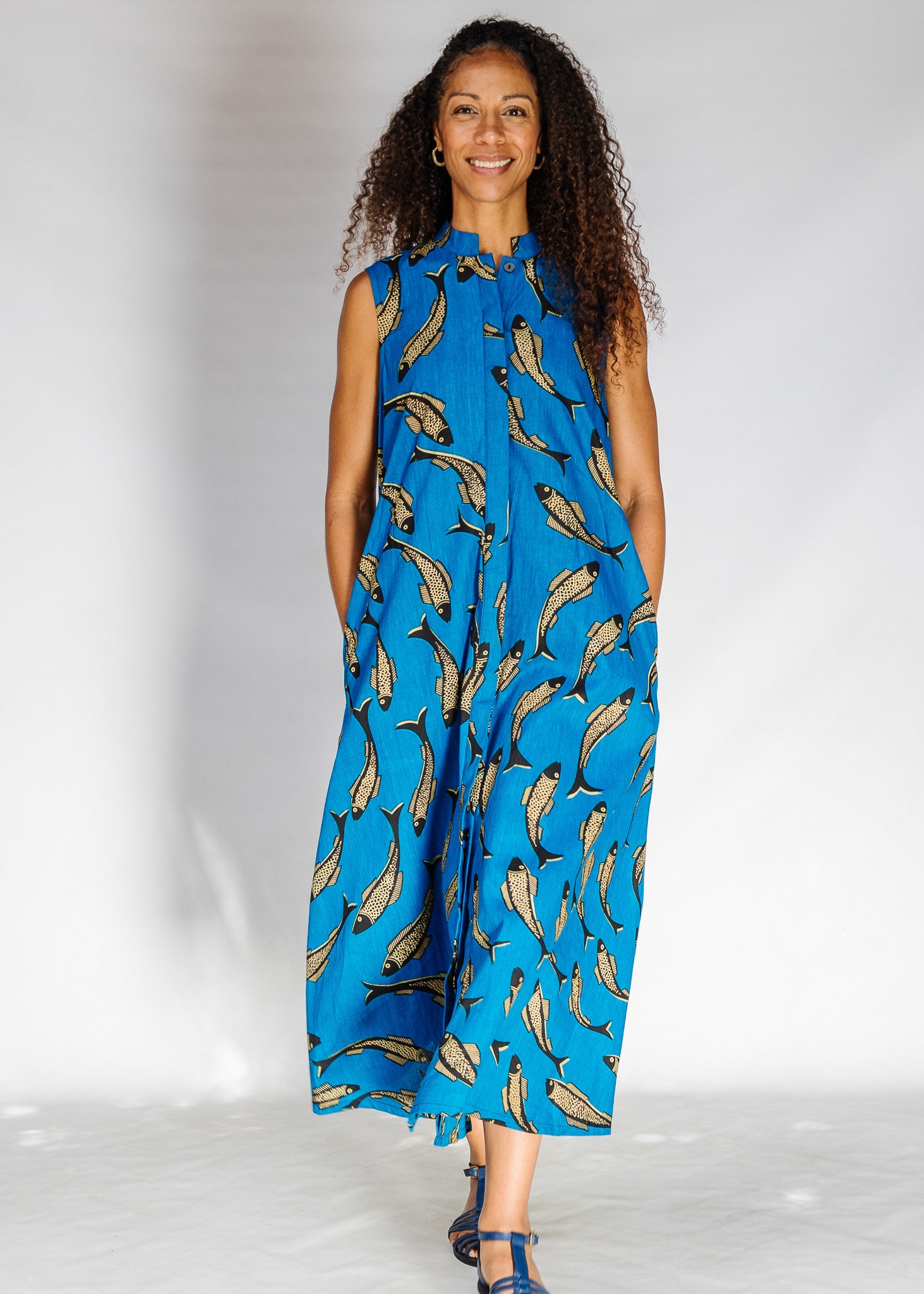 Model wearing blue dress with beige fish print.