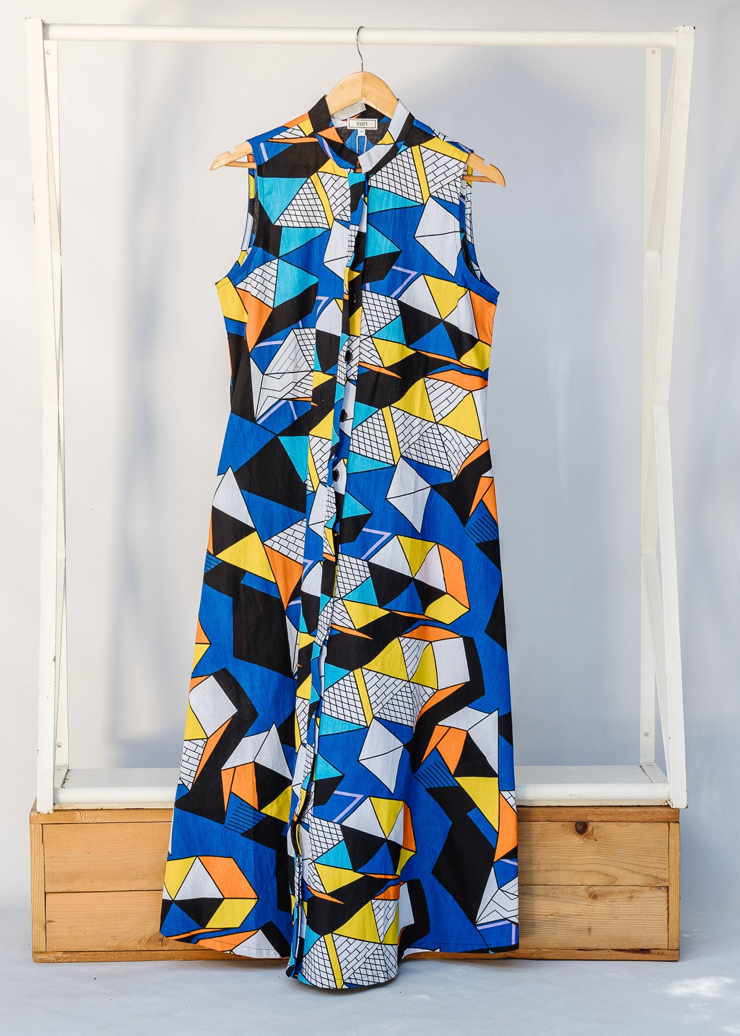 Display of blue dress with yellow, black, orange and white geometric print.