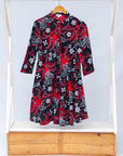 Display of black dress with red and white flowers.