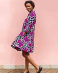 Model wearing purple dress with black and white puzzle print.