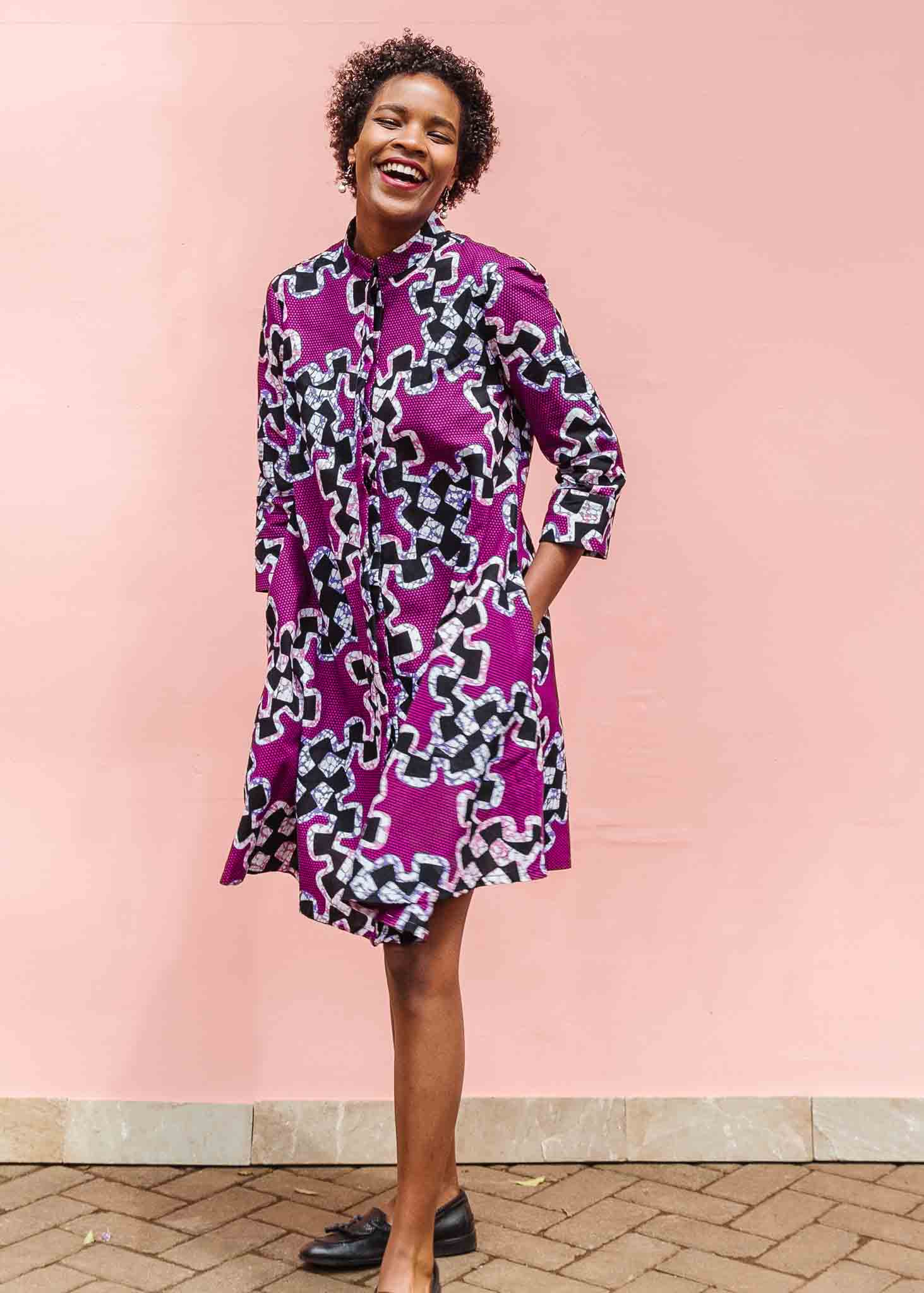 Model wearing purple dress with black and white puzzle print.