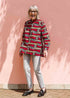 Model wearing red, brown and black scroll printed long sleeve blouse.