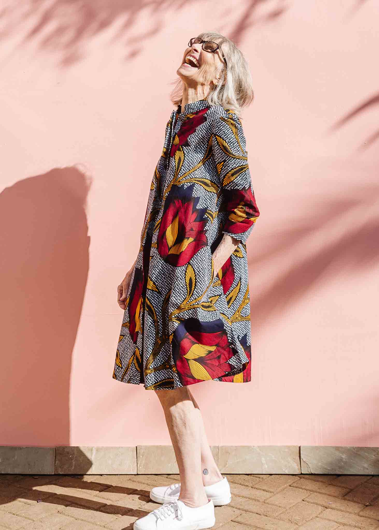 Model wearing red, yellow and navy flower print dress.