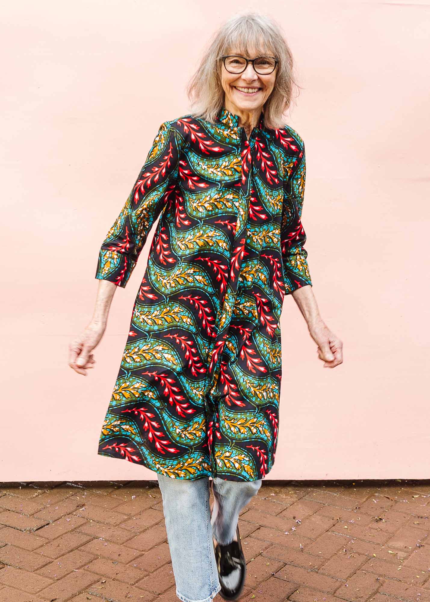 The model is wearing multicolored leaf print dress