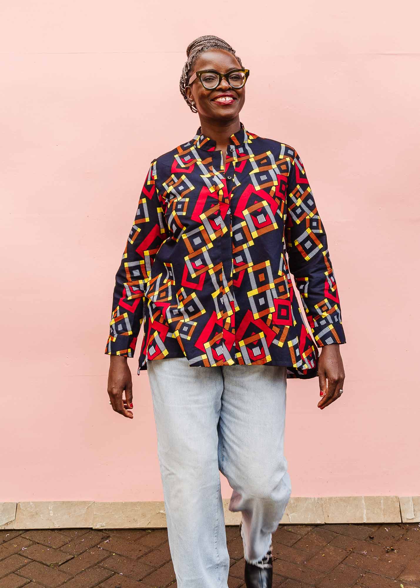 The model is wearing navy shirt with red, orange, yellow and white geometric print 