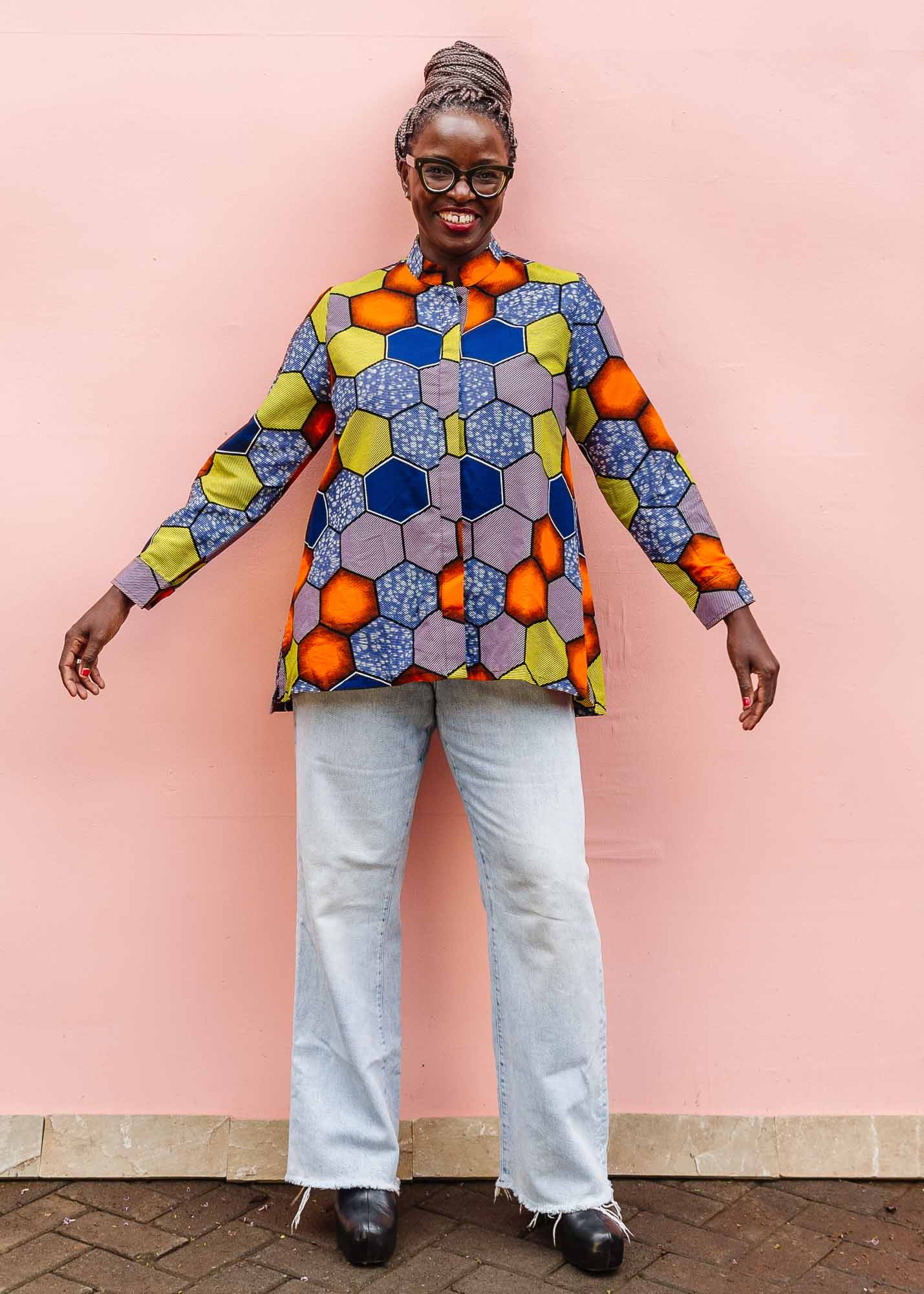 The model is wearing multicolored long sleeved shirt with geometric print 