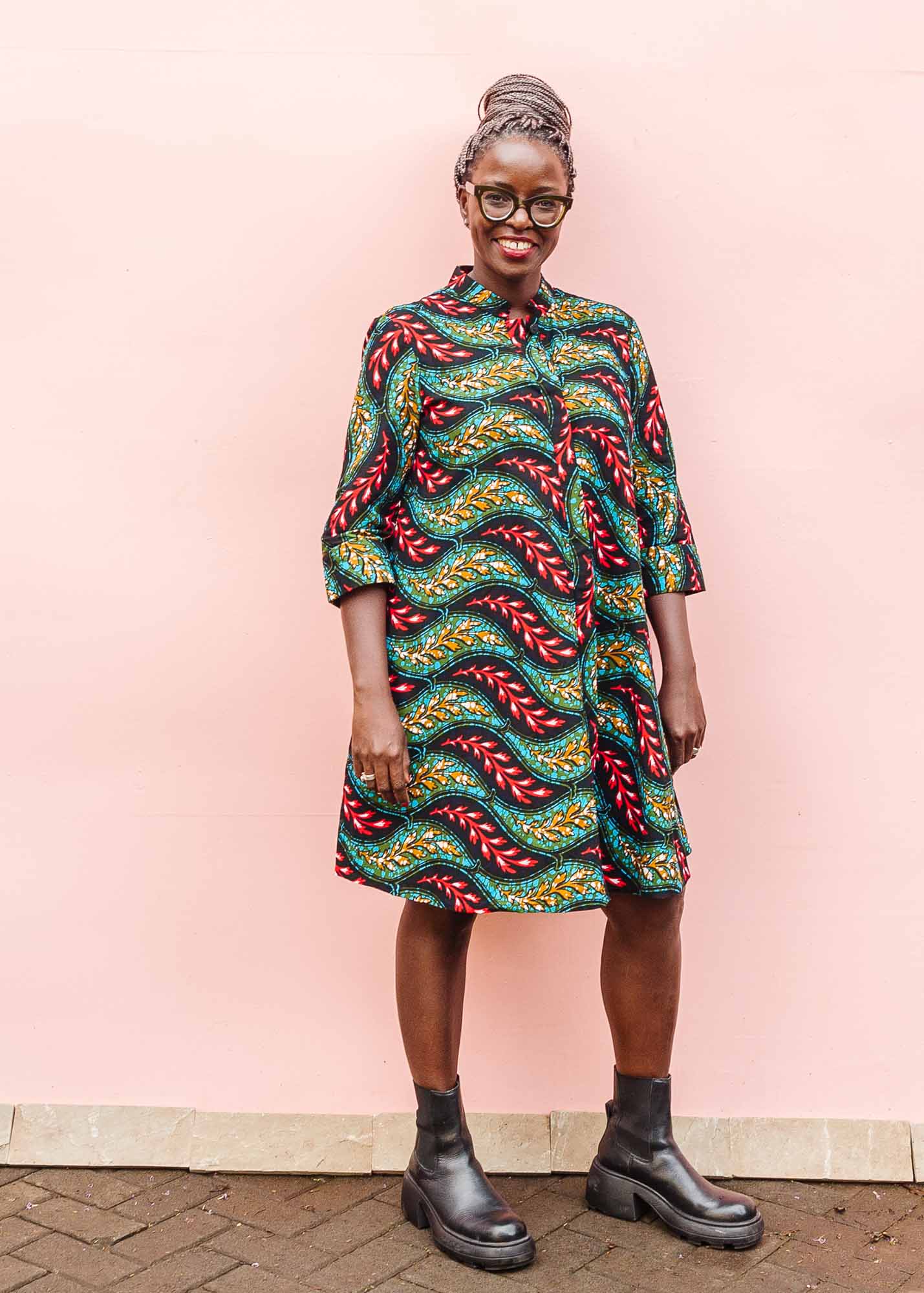 The model is wearing multicolored leaf print dress