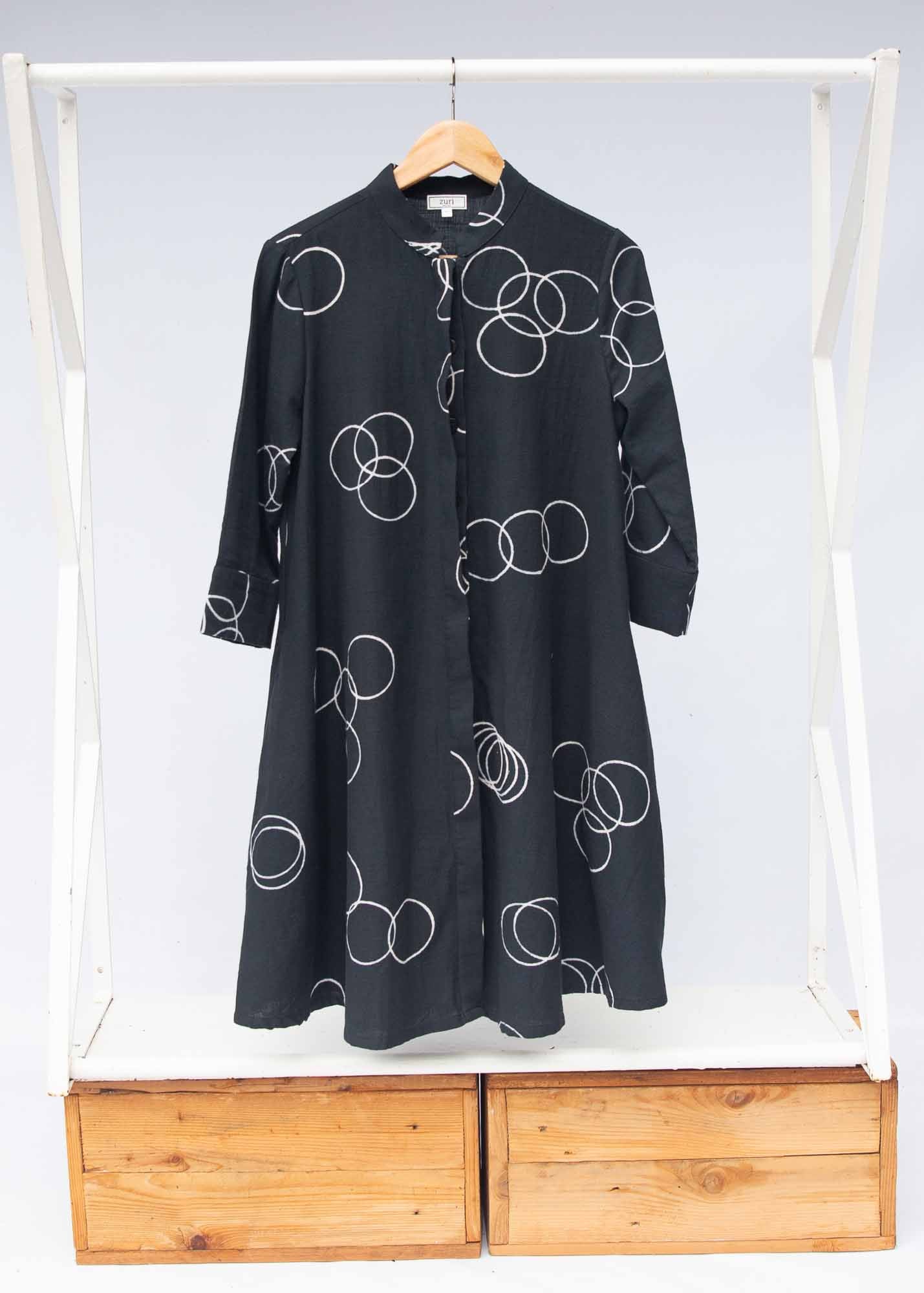 The display of solid black dress with white circular print