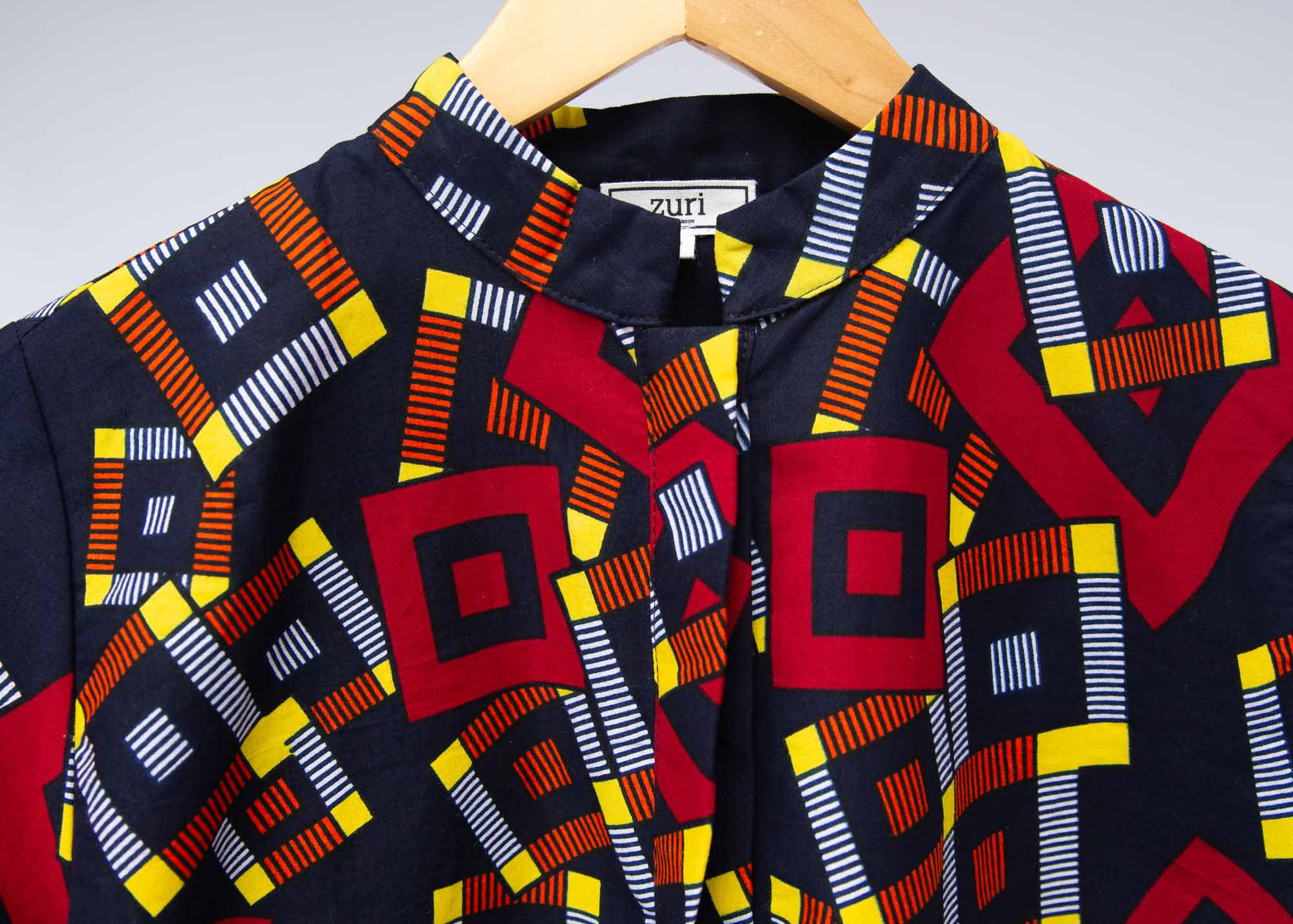 The display of navy shirt with red, orange, yellow and white geometric print 