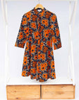 The display of navy dress with orange, brown, black and white floral print