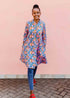 model wearing a lavender, blue and orange fiddlehead fern design dress