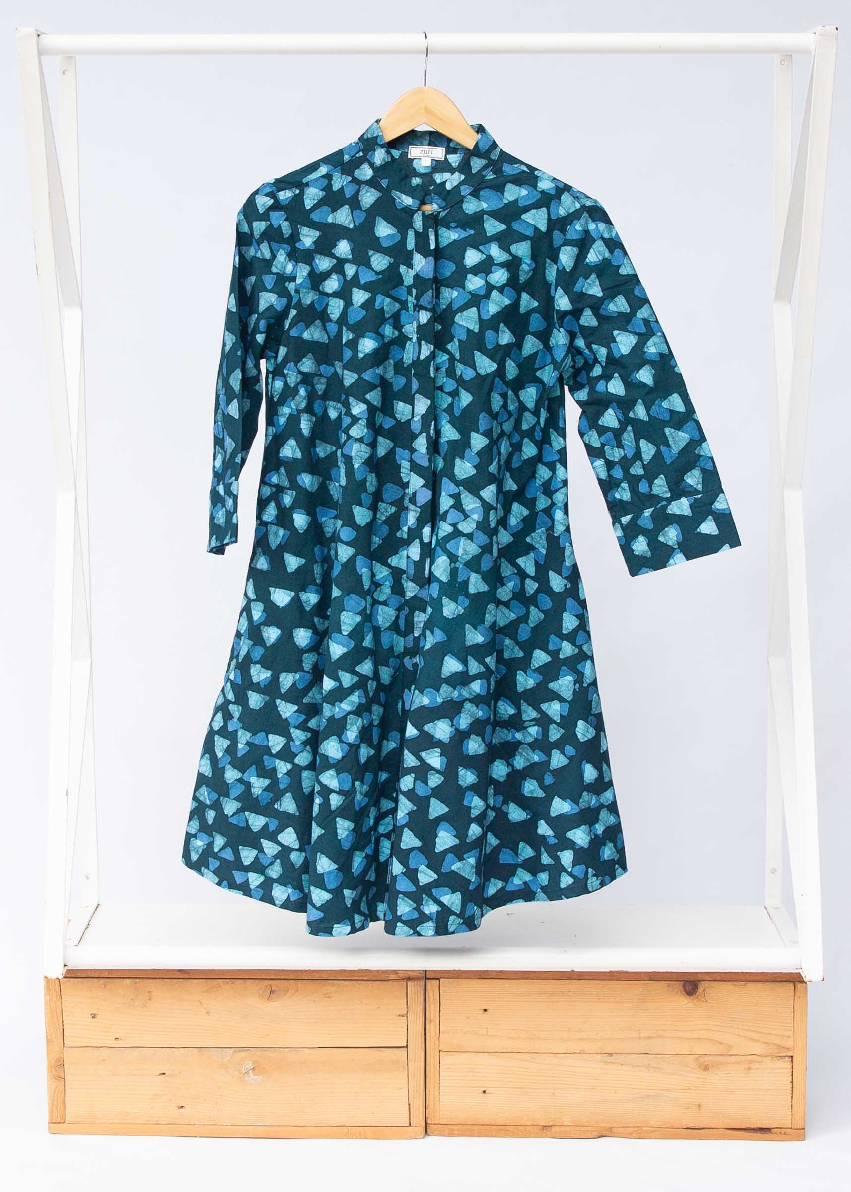 Display of batik dress with hues of blue and teal. 