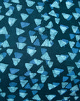 Close up of display of batik dress with hues of blue and teal. 