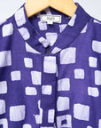 Display of long sleeve purple blouse with small with squares.