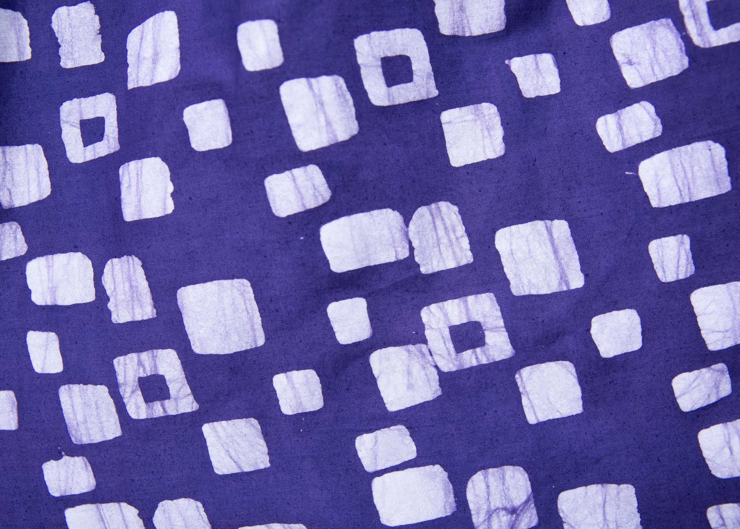 Close up display of long sleeve purple blouse with small with squares.