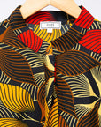 The display of brown, yellow, red and black leaf print dress.