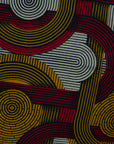 Close up display of red, yellow, gray and black dress with abstract line print.