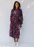 model wearing a red and navy belted midi-length dress