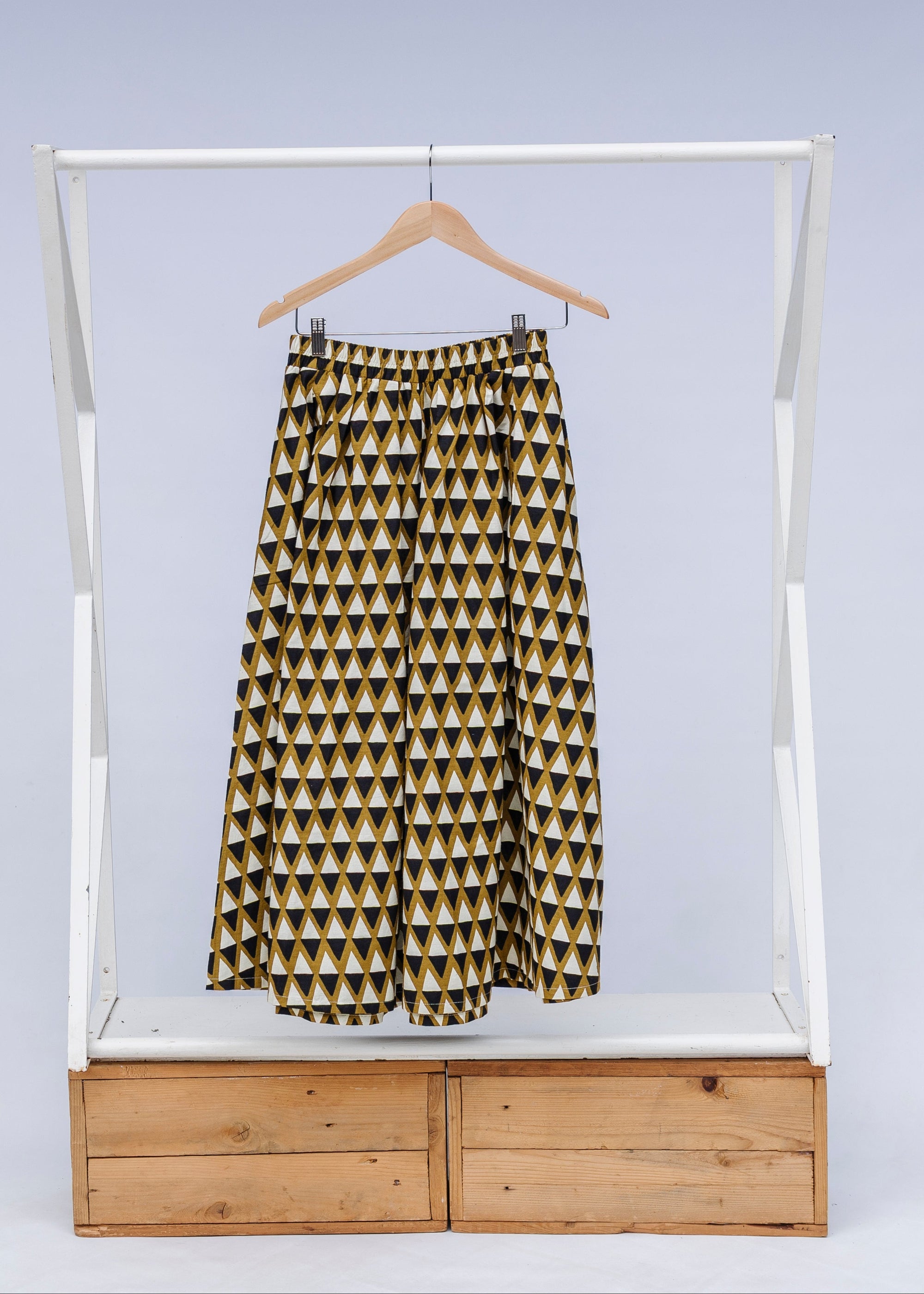 Display of mustard and black triangle print pants.