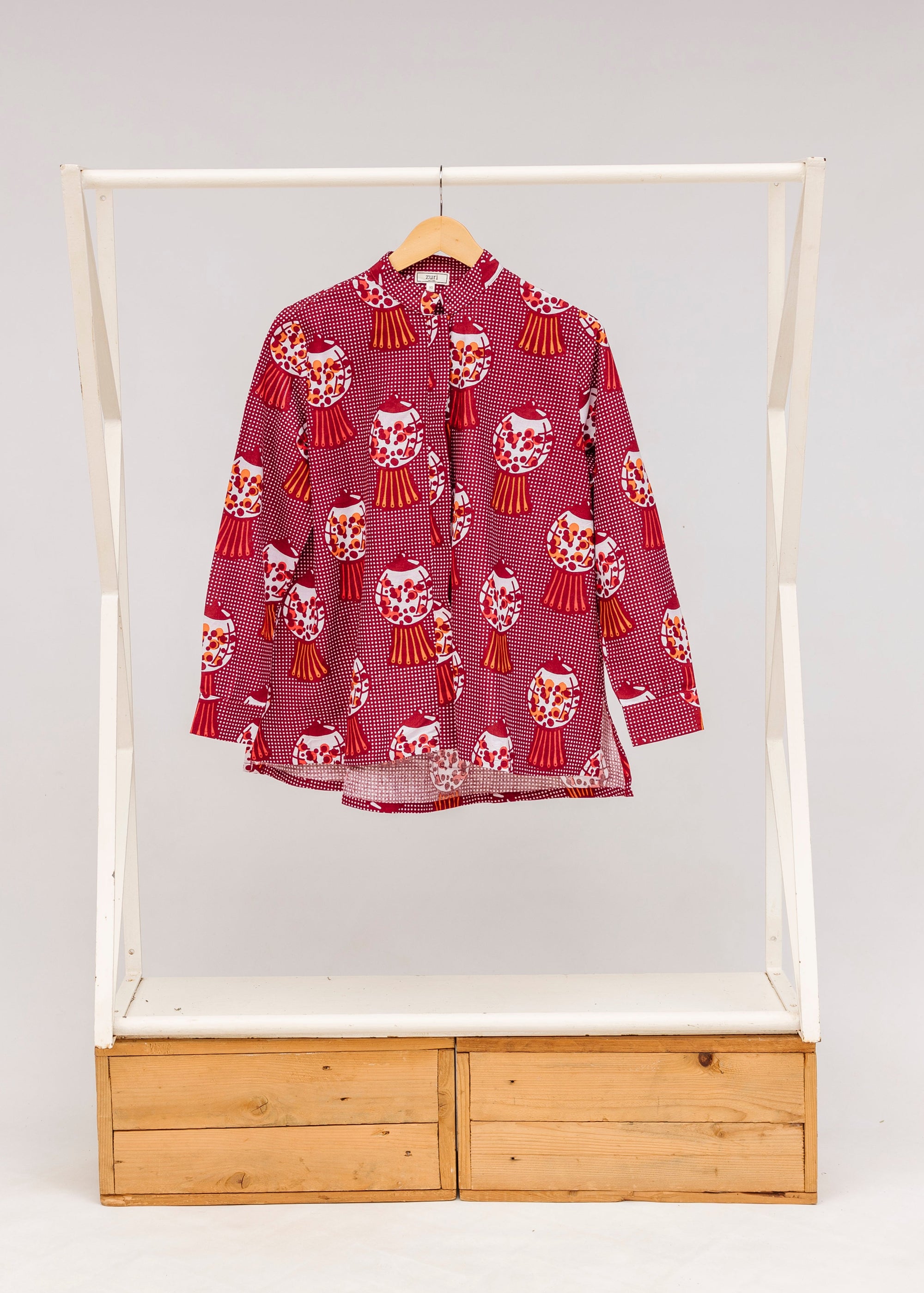 Display of red shirt with orange and white gumball print.